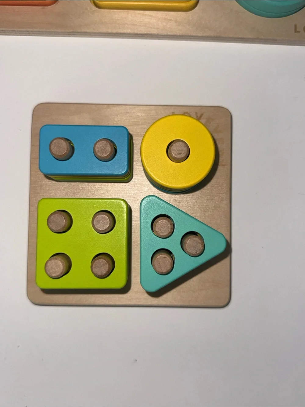 Lovevery Wooden Shape & Stack Toy Set in Green, Yellow, Blue, Orange, Pink